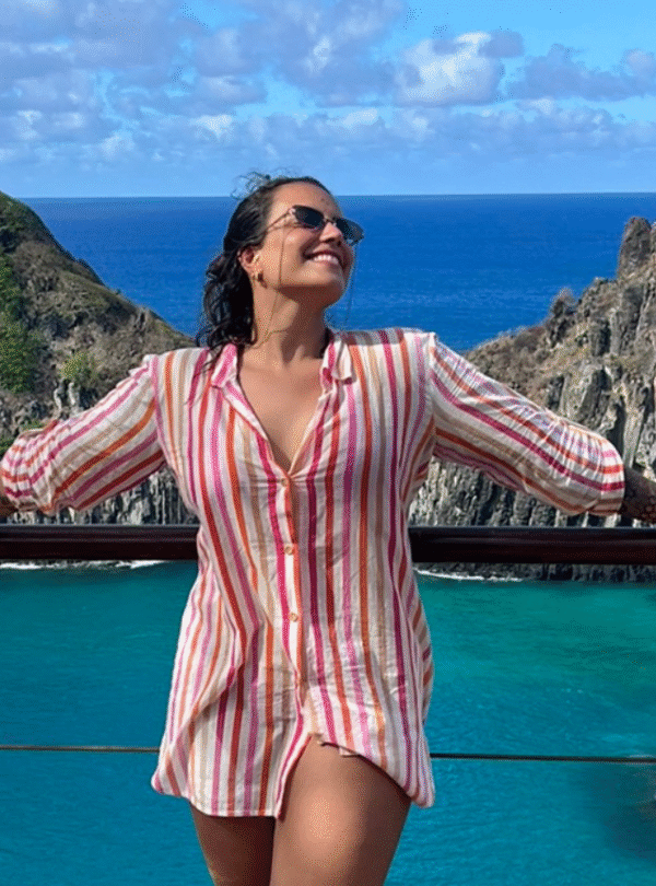 Mulher posando com o Morro Dois Irmãos ao fundo, em Fernando de Noronha